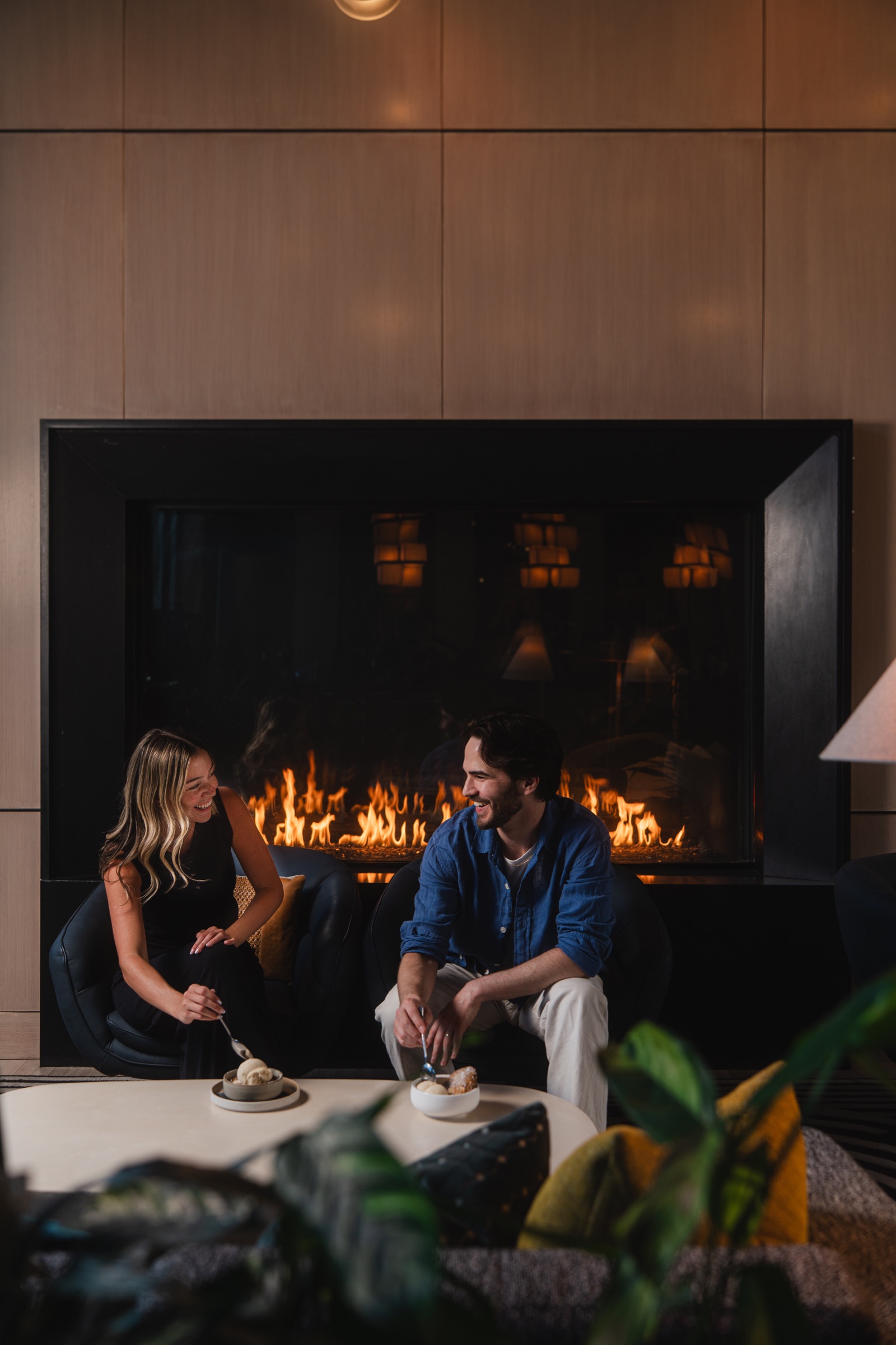 Couple sharing dessert in front of a fireplace