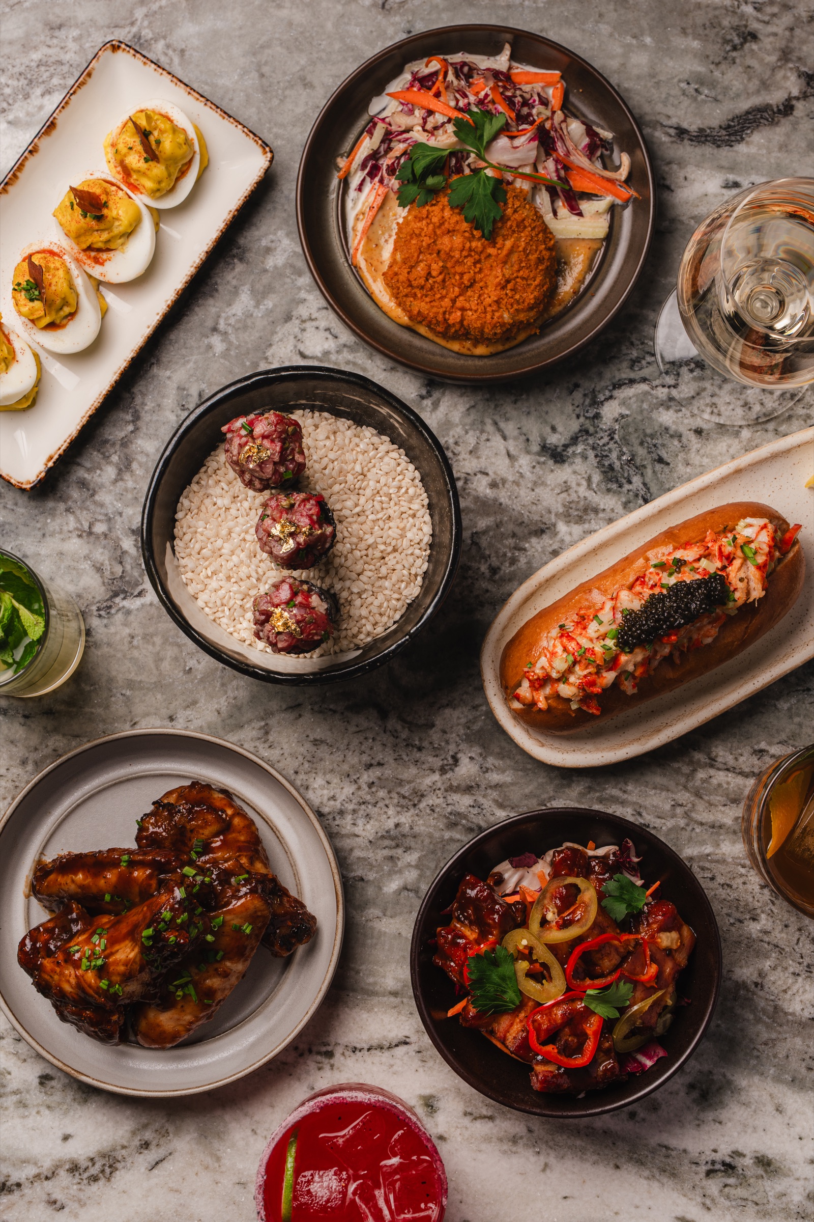 Overhead view of an abundant restaurant table with composed dishes and drinks